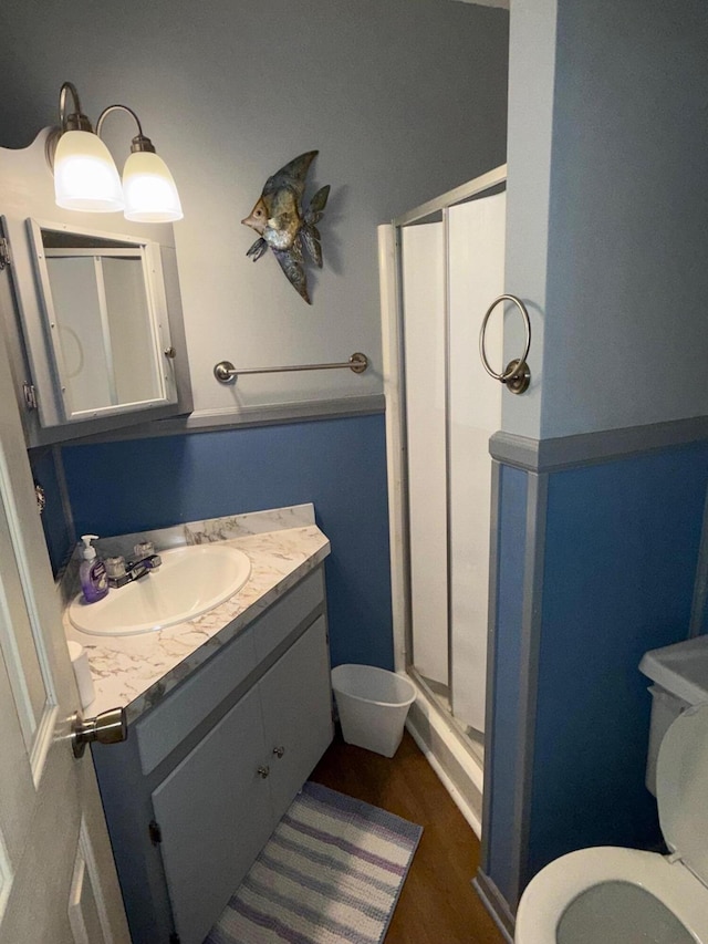 bathroom featuring walk in shower, vanity, and toilet