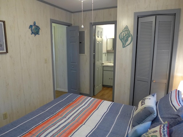 bedroom featuring ensuite bath, ornamental molding, and a closet