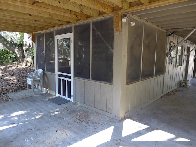 view of home's exterior featuring a sunroom and a patio