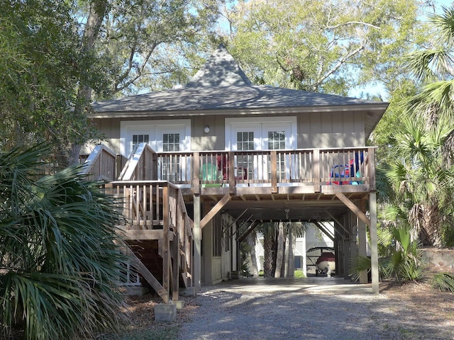 back of property featuring a carport, french doors, and a deck