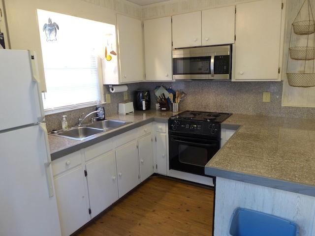 kitchen with white refrigerator, black electric range oven, sink, and decorative backsplash