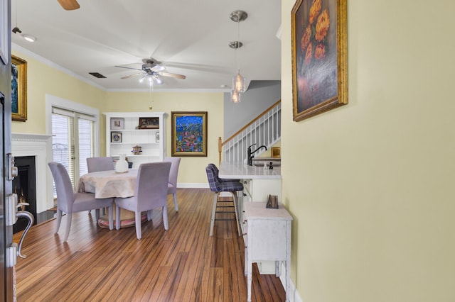 dining room featuring ceiling fan, dark hardwood / wood-style flooring, crown molding, and built in features