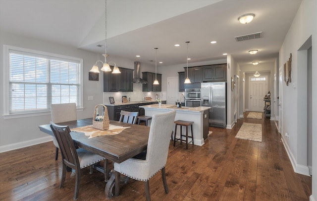 dining area featuring sink, dark wood-type flooring, and lofted ceiling