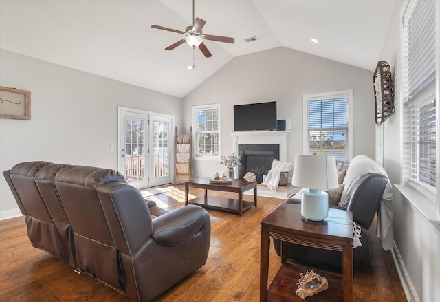 living room featuring ceiling fan, wood-type flooring, and vaulted ceiling