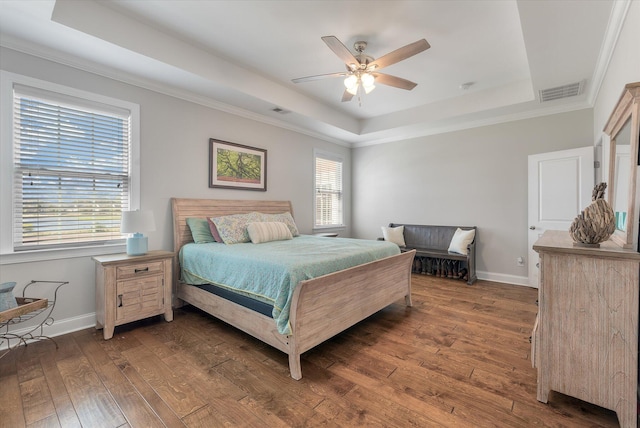 bedroom with multiple windows, dark hardwood / wood-style floors, and a raised ceiling