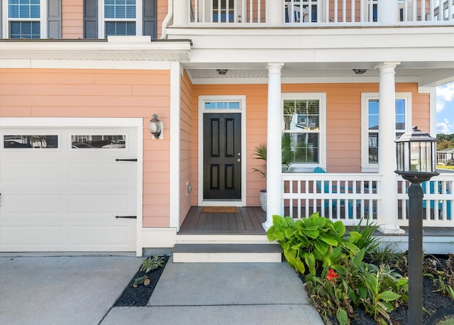 view of exterior entry featuring covered porch and a garage