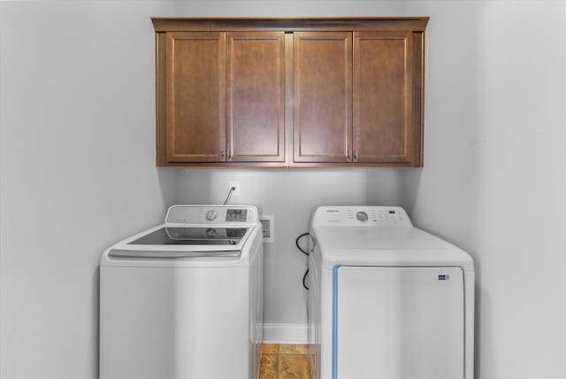 clothes washing area with independent washer and dryer and cabinets