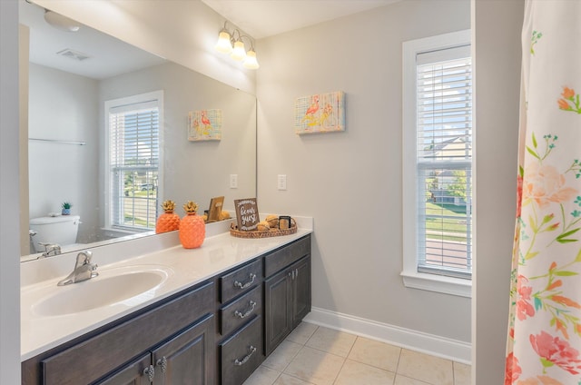 bathroom featuring vanity, tile patterned flooring, toilet, and plenty of natural light