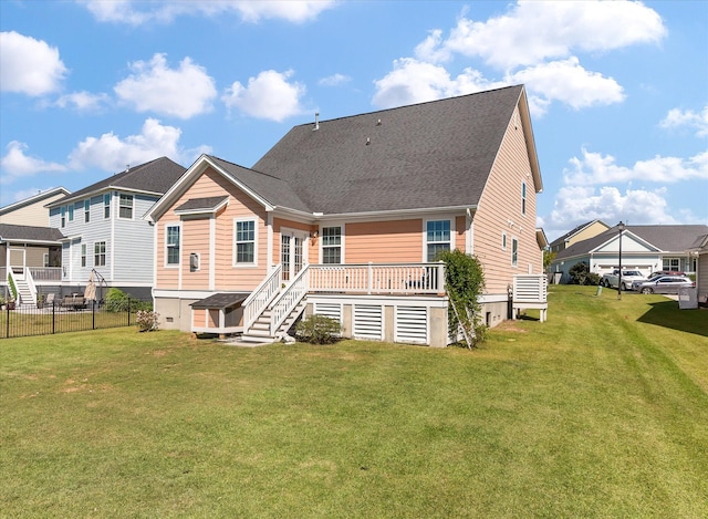 rear view of house featuring a wooden deck and a lawn