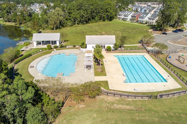 view of pool featuring a patio, a lawn, and a water view