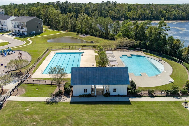 view of swimming pool with a patio, a yard, and a water view