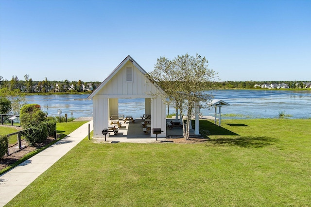 view of dock with a water view, a gazebo, and a yard