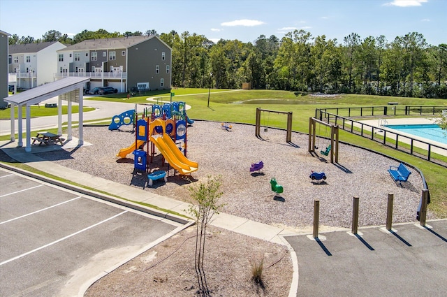 surrounding community featuring a playground, a yard, and a pool