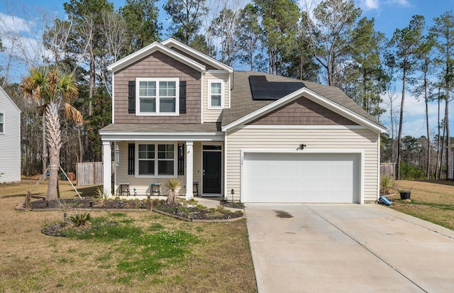 view of front of house featuring a front yard, solar panels, an attached garage, covered porch, and concrete driveway