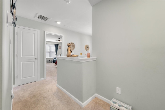 corridor featuring visible vents, carpet floors, baseboards, and an upstairs landing