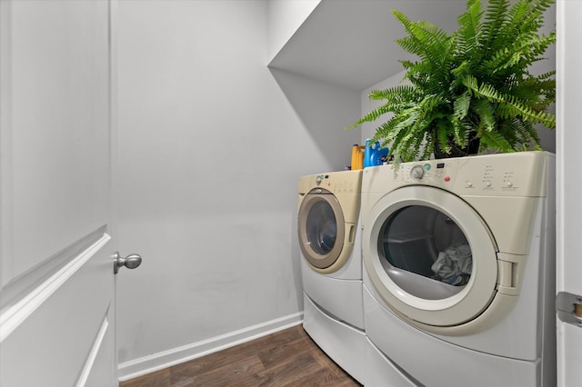 laundry area featuring washer and dryer, baseboards, dark wood-style floors, and laundry area