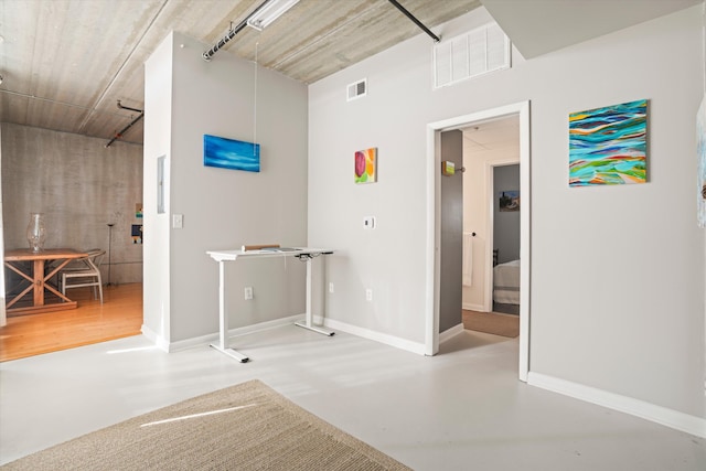 interior space featuring baseboards, finished concrete floors, and visible vents