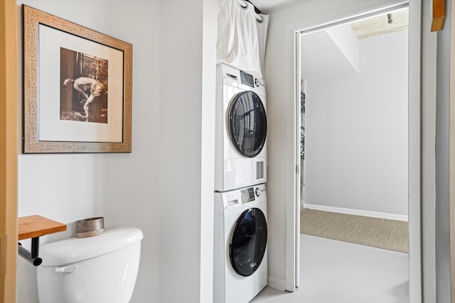 washroom with stacked washer and dryer and laundry area