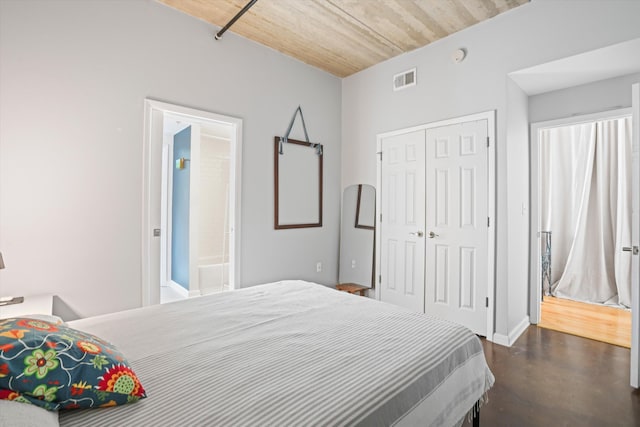 bedroom with finished concrete flooring, baseboards, a closet, and visible vents