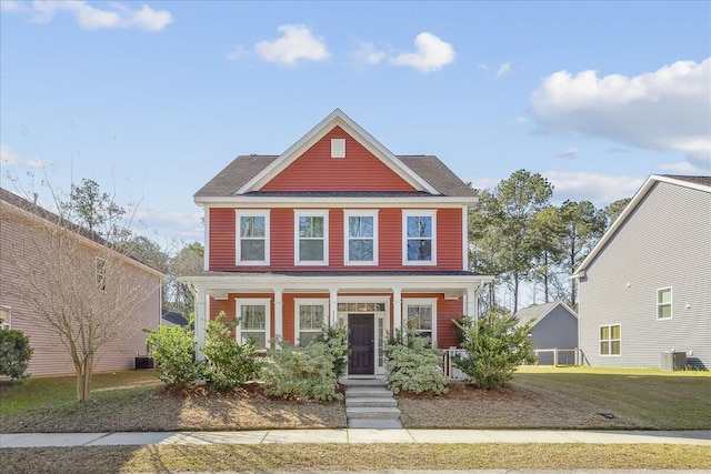 view of front of home with a front lawn, central AC unit, and covered porch