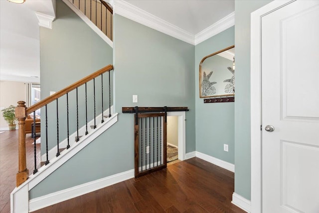 staircase featuring wood finished floors, baseboards, and ornamental molding