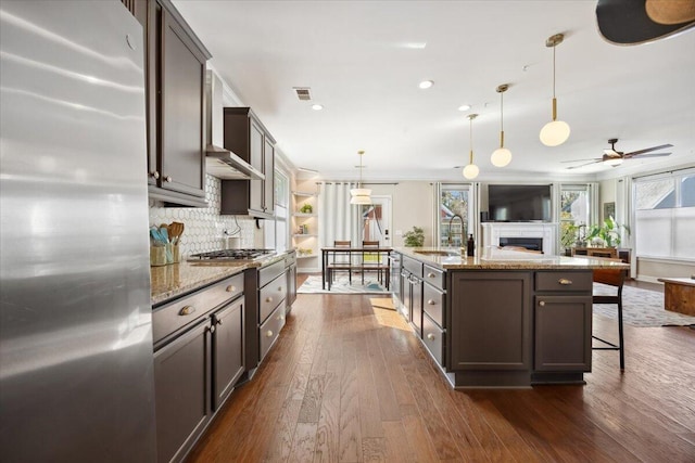 kitchen featuring visible vents, a sink, appliances with stainless steel finishes, open floor plan, and backsplash