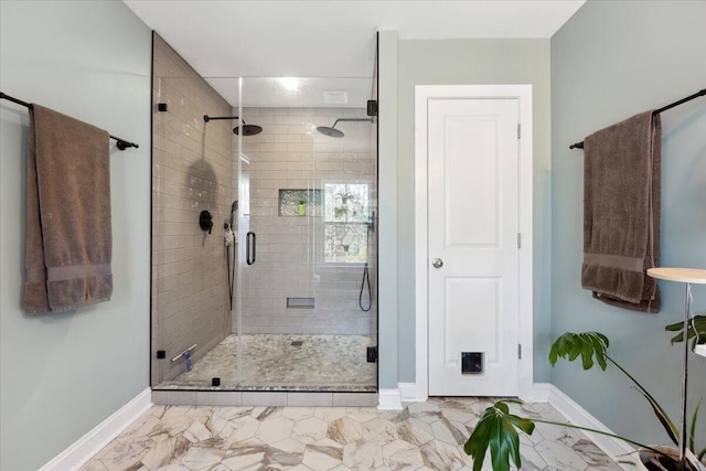 bathroom with a shower stall, baseboards, and marble finish floor