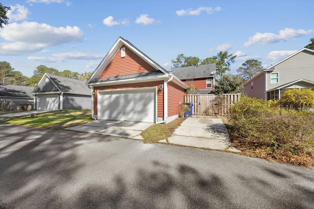 view of front facade featuring a garage, an outdoor structure, and fence