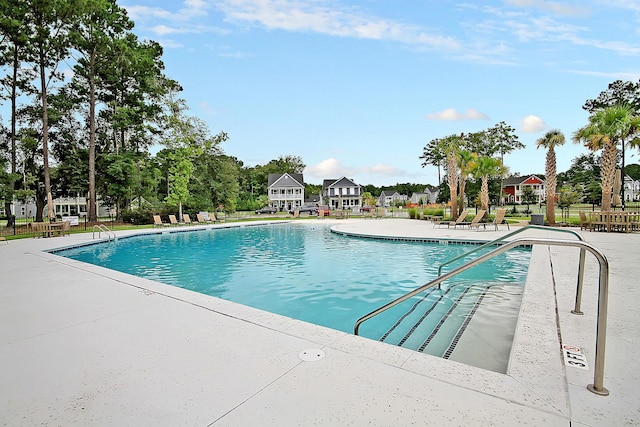 community pool with a patio and fence