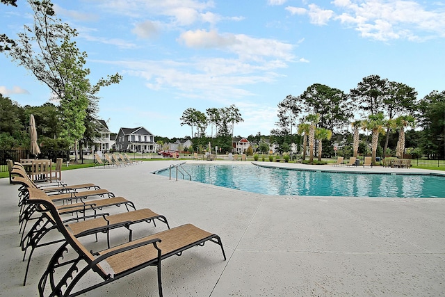 pool with a patio and fence