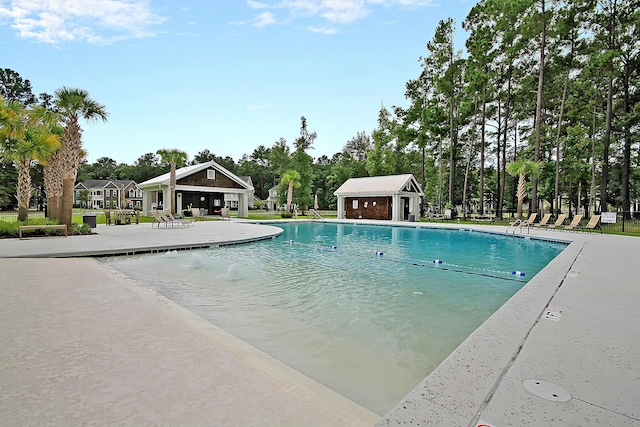 community pool featuring a patio area and an outbuilding