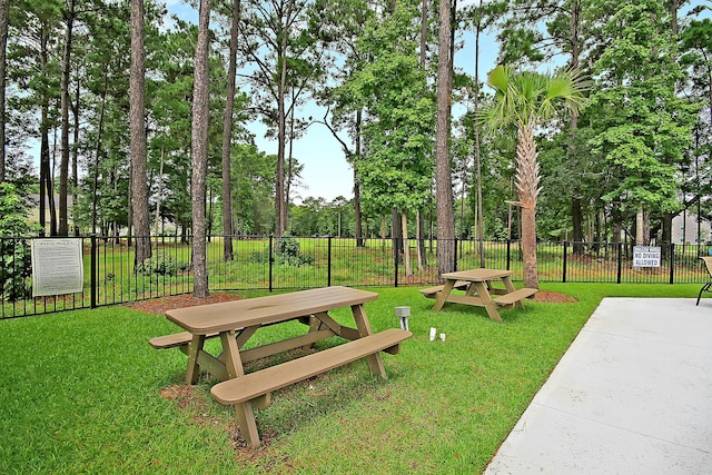 view of property's community with a yard and fence