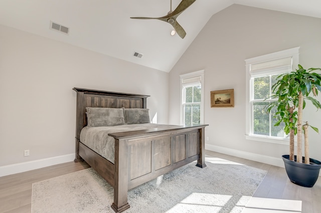 bedroom with light hardwood / wood-style flooring, high vaulted ceiling, and ceiling fan