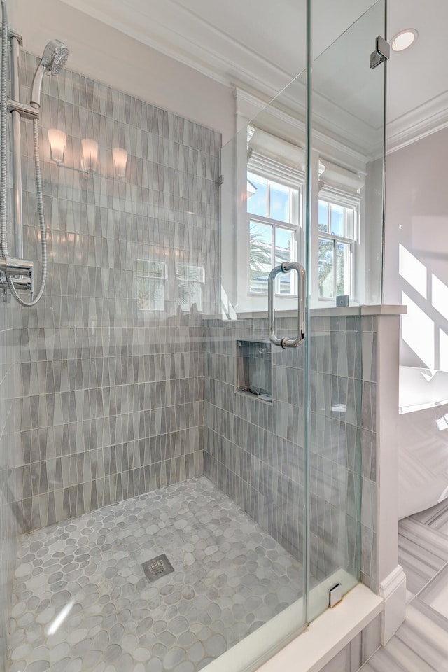 bathroom featuring a shower with door and crown molding