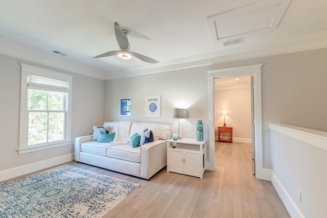 living room with ornamental molding, ceiling fan, and light wood-type flooring