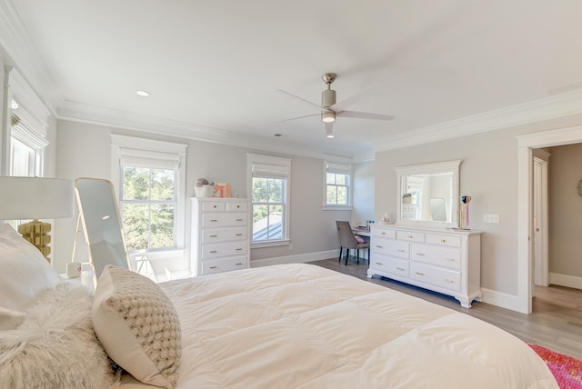 bedroom featuring ornamental molding, multiple windows, and light hardwood / wood-style flooring