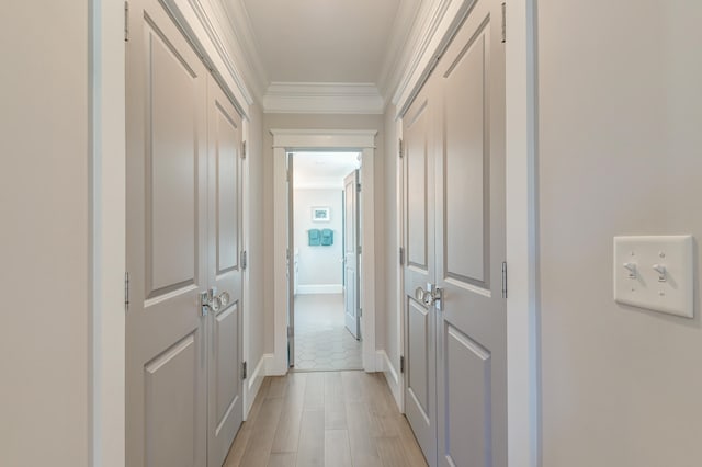 corridor featuring ornamental molding and light wood-type flooring