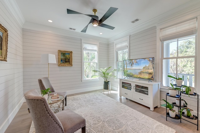 sitting room with crown molding, light hardwood / wood-style flooring, and ceiling fan