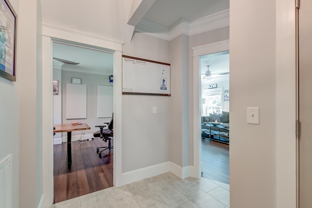 corridor with ornamental molding and light hardwood / wood-style flooring