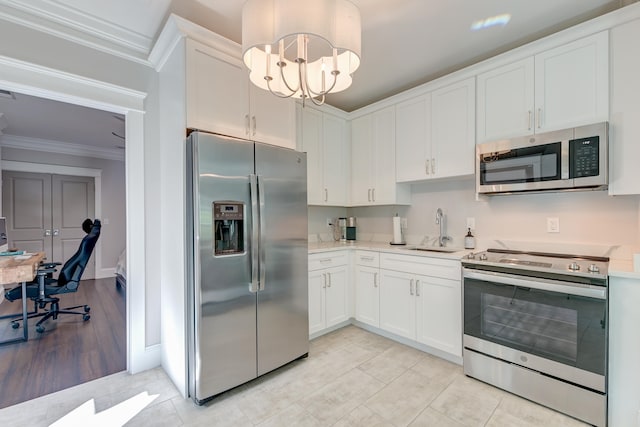 kitchen featuring white cabinetry, ornamental molding, stainless steel appliances, and sink