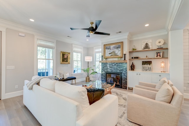 living room featuring light hardwood / wood-style flooring, a fireplace, and ornamental molding