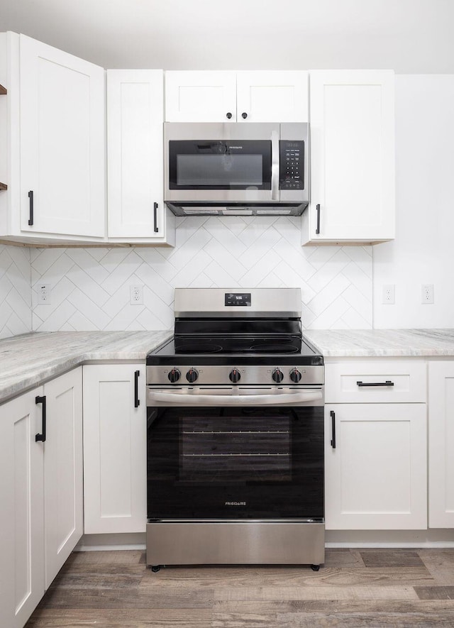 2924 Chicora Ave, North Charleston, SC 29405 - kitchen featuring appliances with stainless steel finishes, white cabinets, and light stone countertops