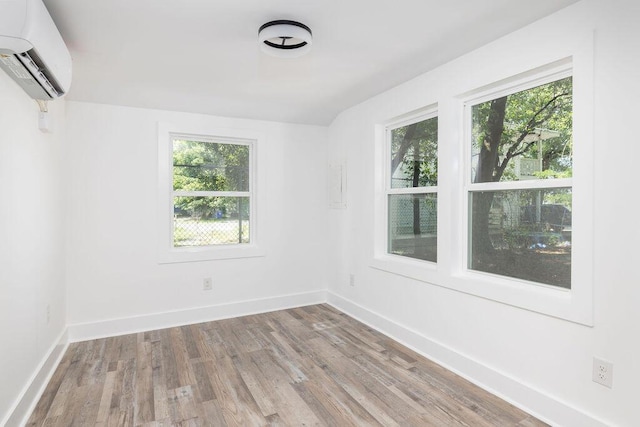 2924 Chicora Ave, North Charleston, SC 29405 - unfurnished room with a wall unit AC, plenty of natural light, and wood finished floors