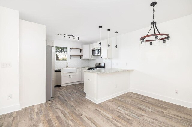 2924 Chicora Ave, North Charleston, SC 29405 - kitchen with appliances with stainless steel finishes, a peninsula, open shelves, tasteful backsplash, and light wood-style flooring