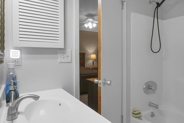 bathroom featuring bathing tub / shower combination, ceiling fan, and sink