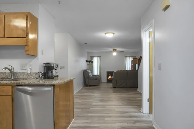 kitchen with light hardwood / wood-style floors, stainless steel dishwasher, ceiling fan, and sink