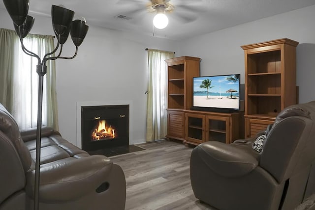 living room with ceiling fan and light hardwood / wood-style floors