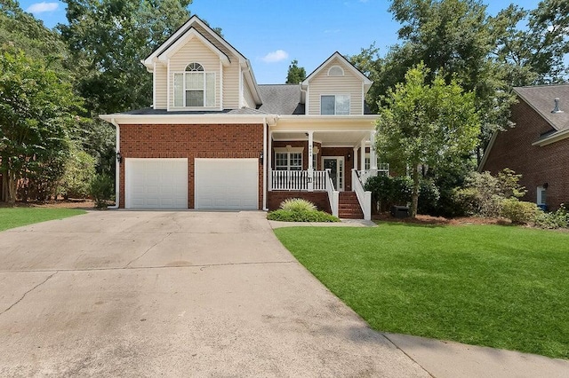 view of front of house featuring a garage, covered porch, and a front yard