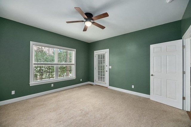 carpeted spare room with ceiling fan