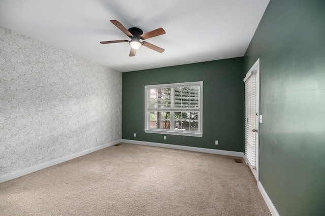 empty room featuring carpet floors and ceiling fan